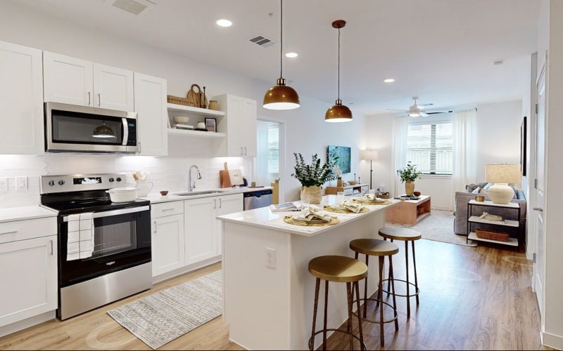 kitchen with white cabinets island and hanging lights